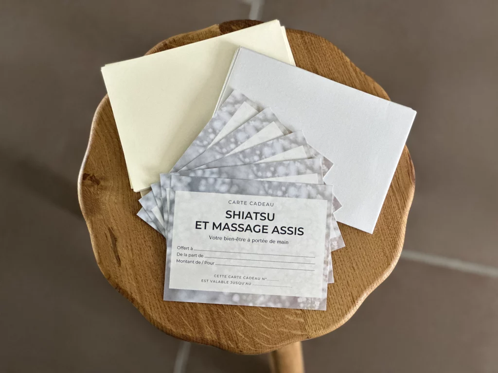 Cartes cadeau pour un shiatsu ou un massage Amma assis, posées sur un tabouret